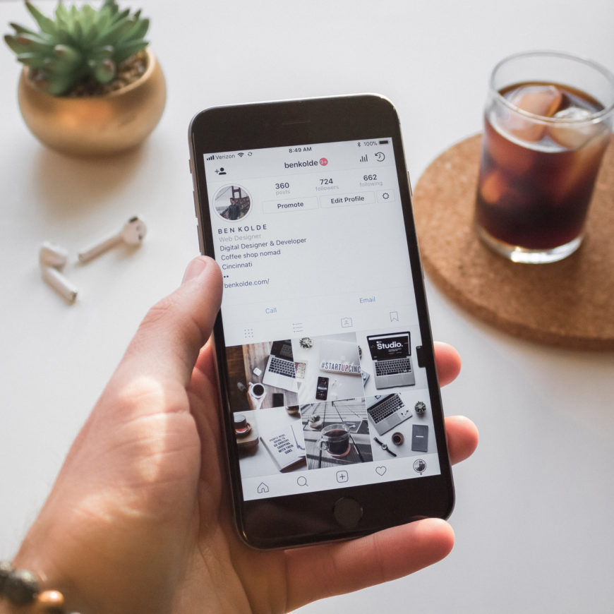 Instagram feed next to airpods and cofee