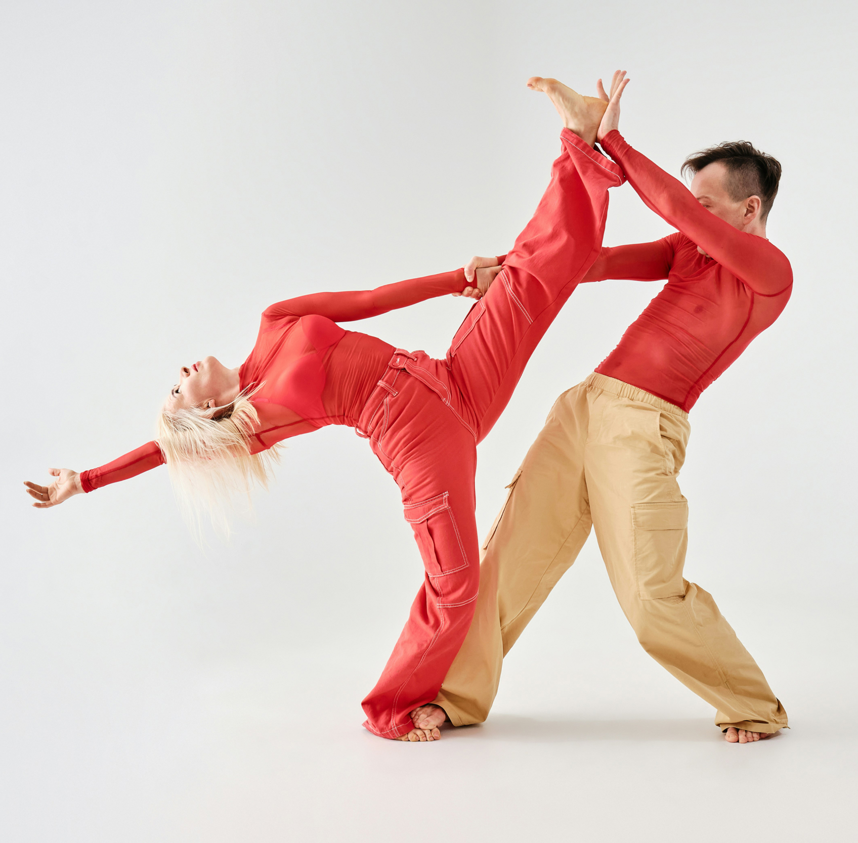 Claude responded: Two dancers perform a dynamic lift against a plain white background, both dressed in red. Two dancers perform a dynamic lift against a plain white background, both dressed in red.